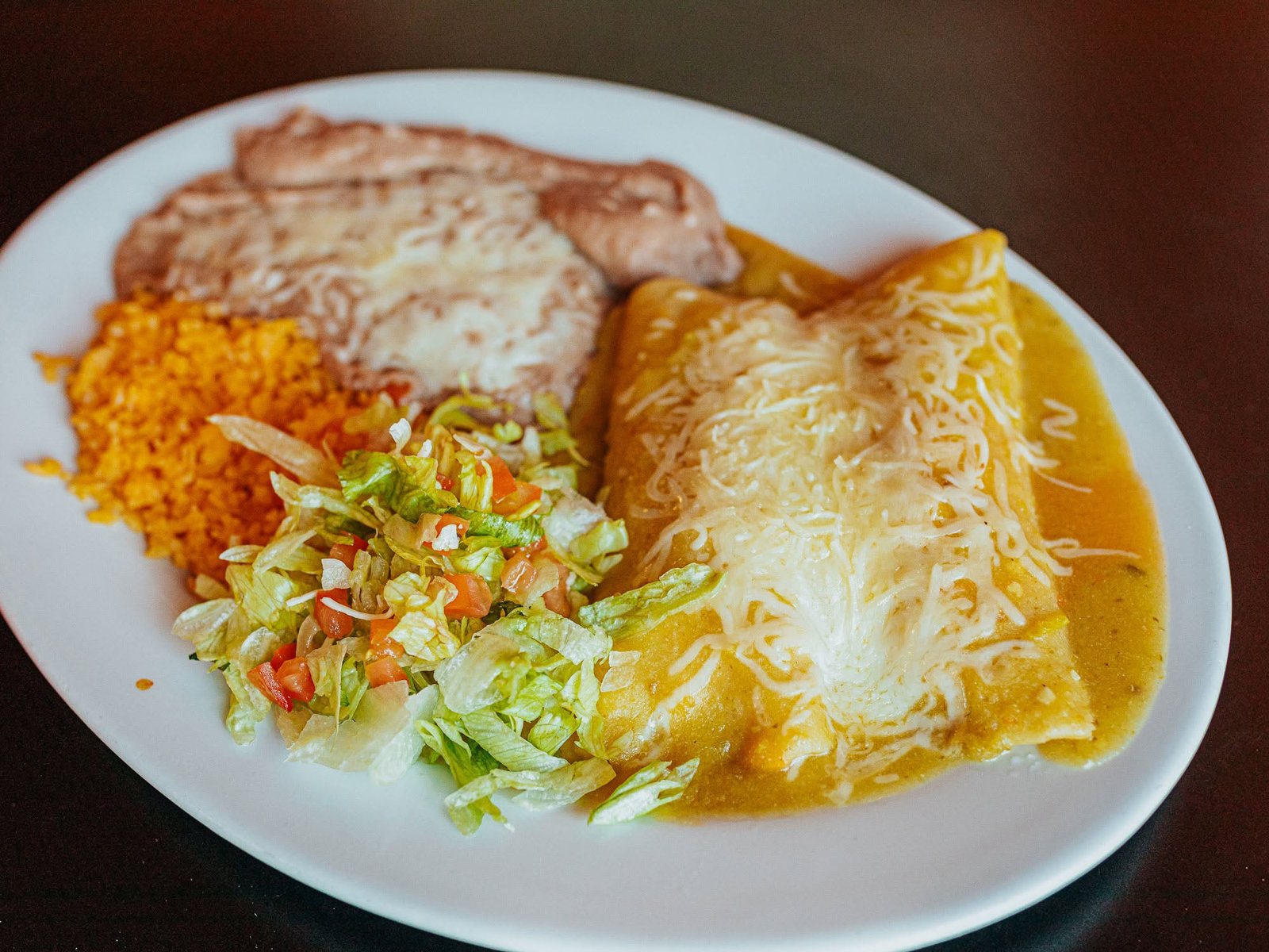 Enchiladas verdes with rice, beans, and salad